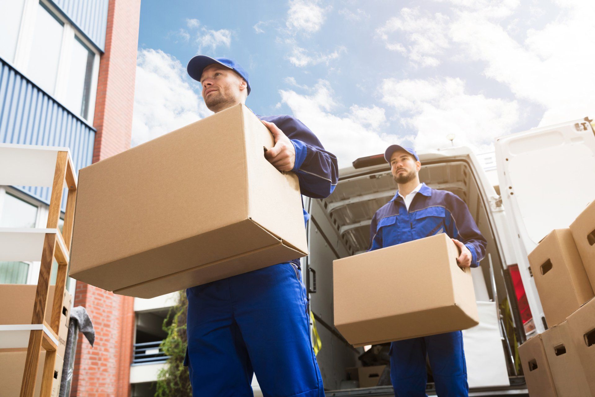 Two Delivery Men Carrying Cardboard Box — Corrimal, NSW — Pride Removals Two Delivery Men Carrying Cardboard Box — Corrimal, NSW — Pride Removals