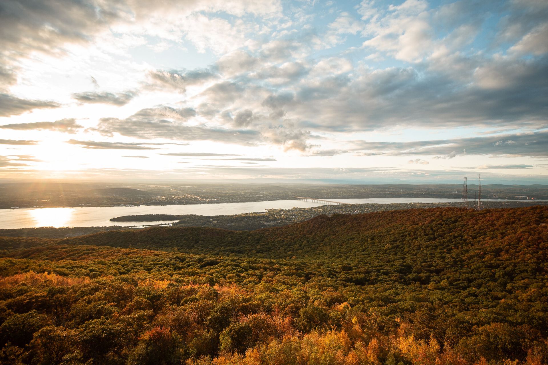 An aerial view of a river surrounded by trees at sunset.