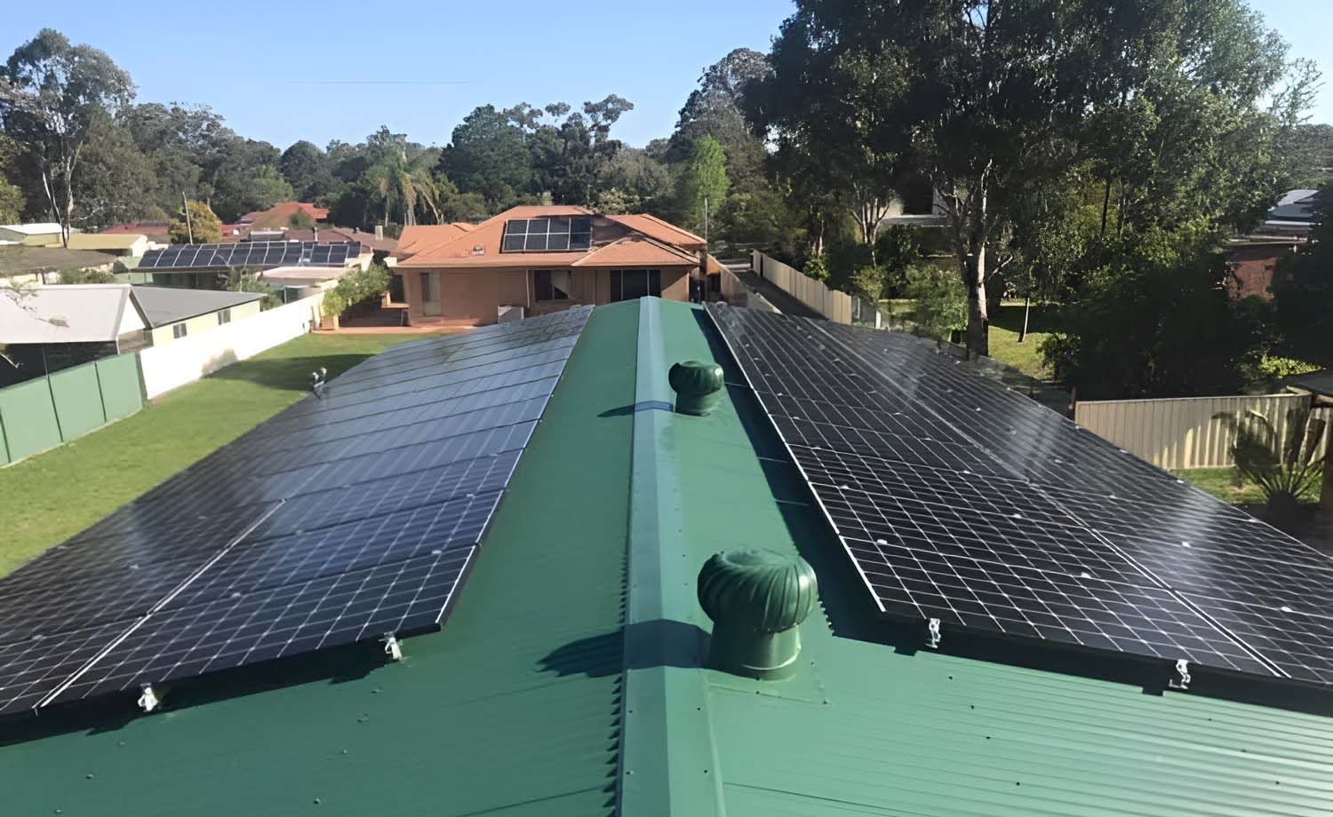 A Green Roof With Black Solar Panels On It — GJT Electrical In Warners Bay, NSW