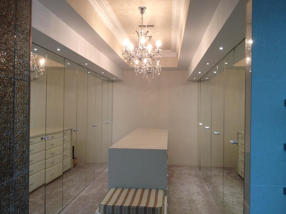 A Walk In Closet With A Chandelier Hanging From The Ceiling — GJT Electrical In Warners Bay, NSW
