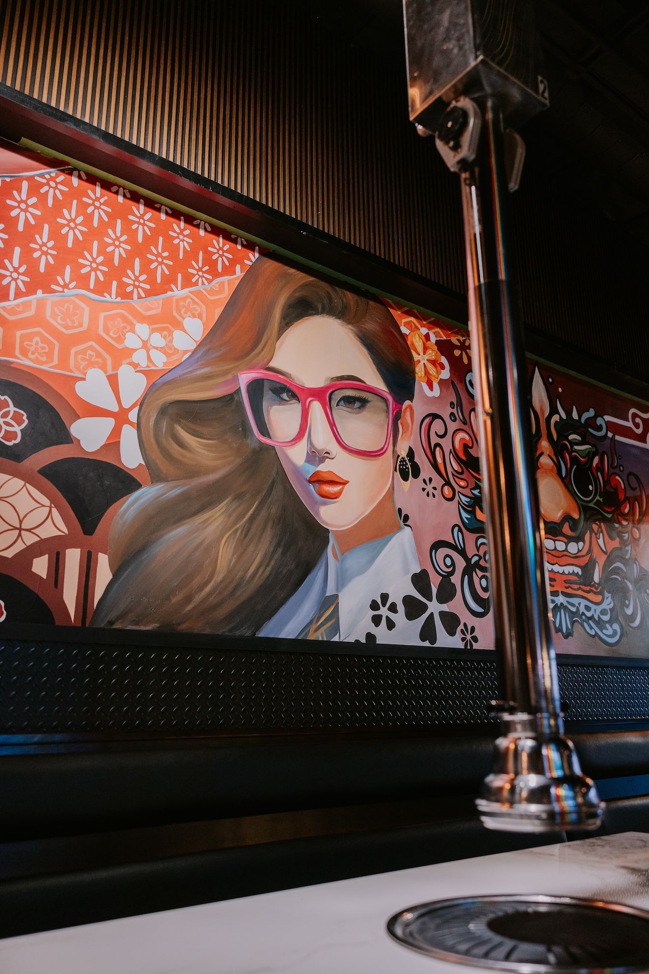 there is a painting of a woman wearing glasses on the wall .