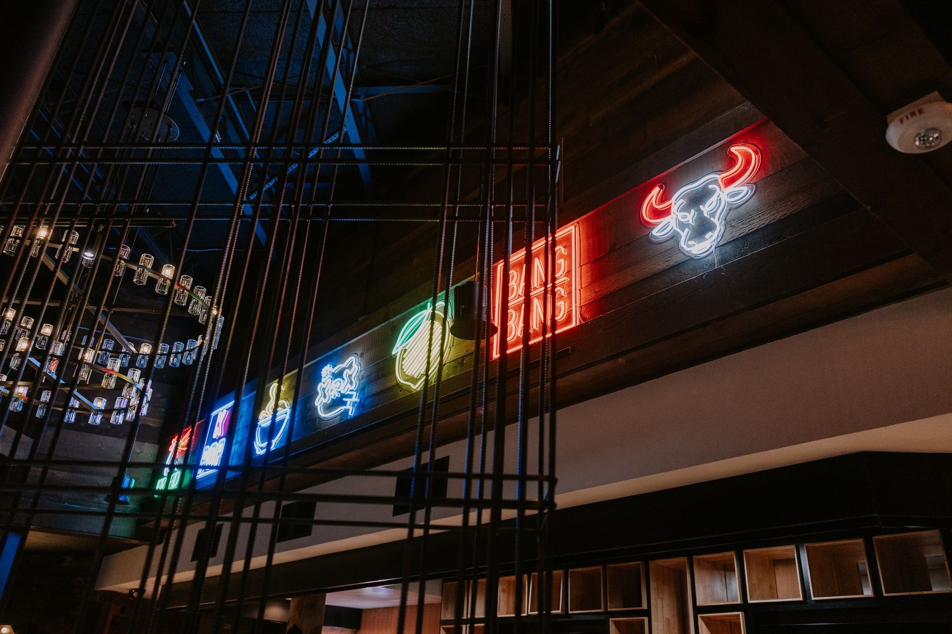 a neon sign with a bull on it is hanging from the ceiling of a restaurant .