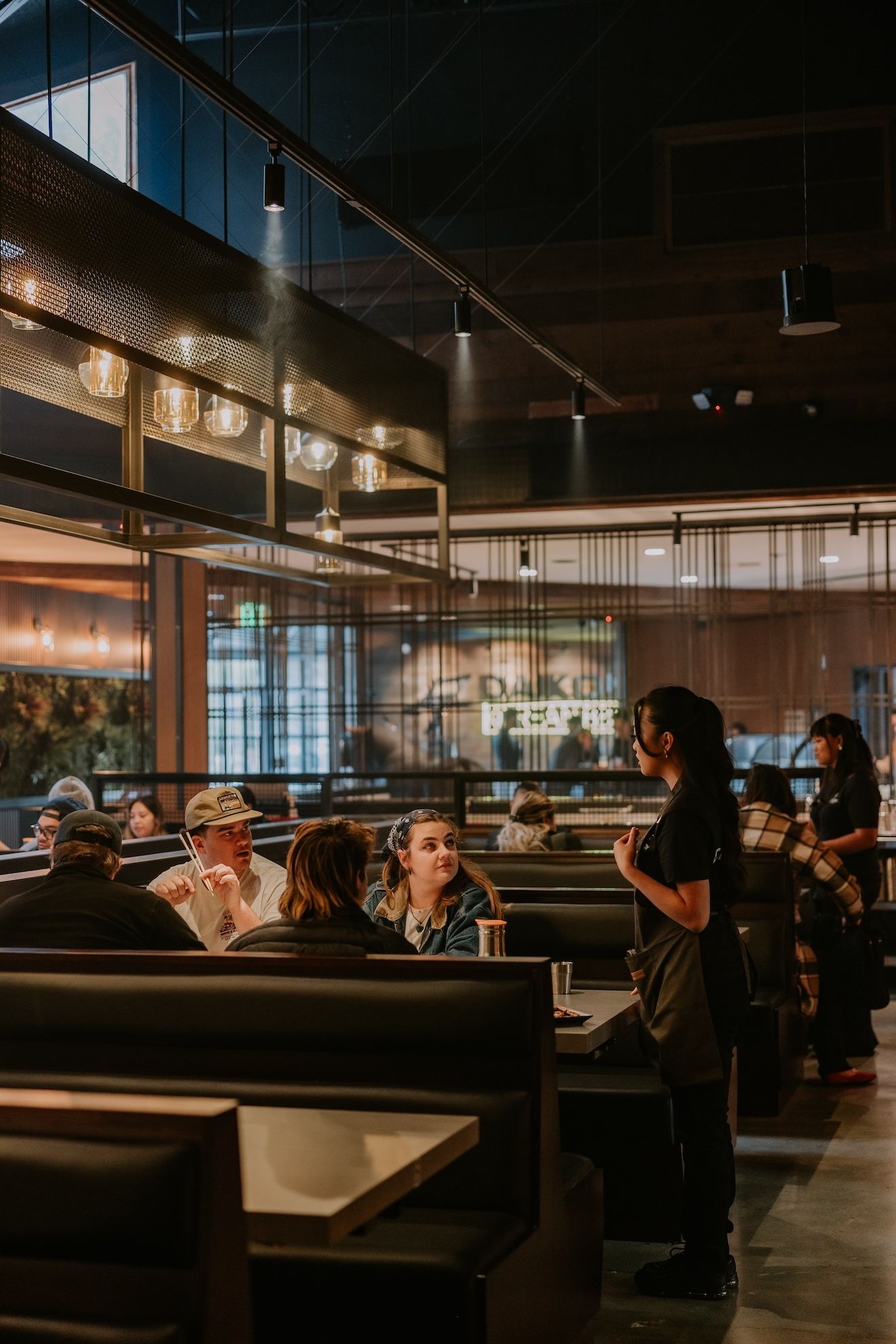 a group of people are sitting at tables in a restaurant .
