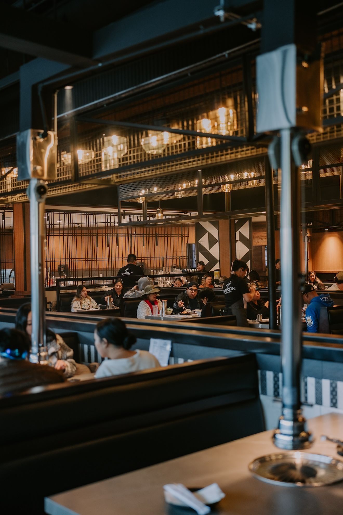 a group of people are sitting at tables in a restaurant.