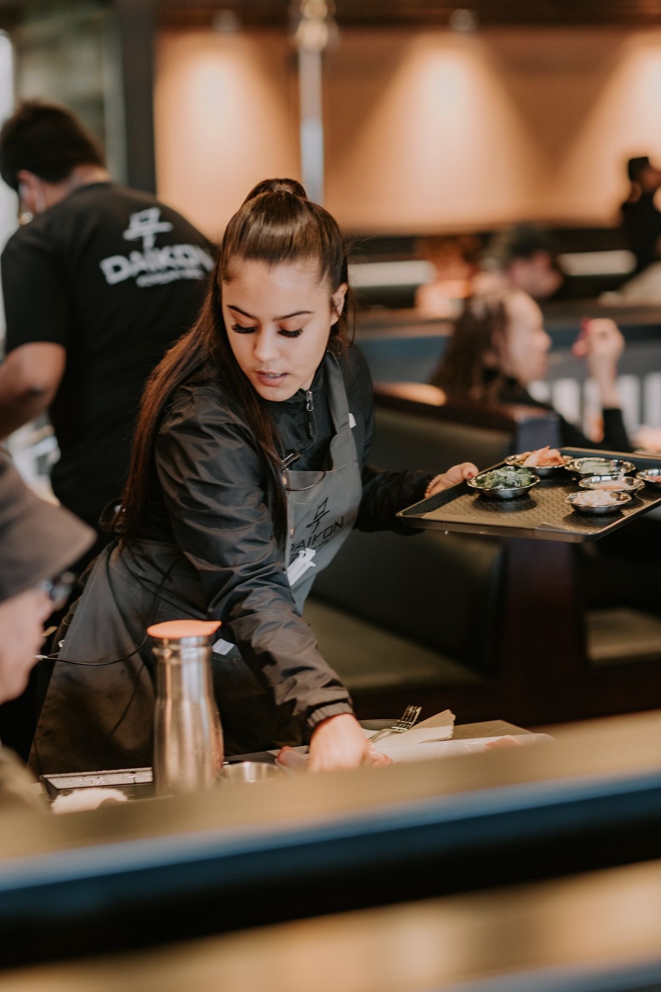 a waitress is holding a tray of food in a restaurant .