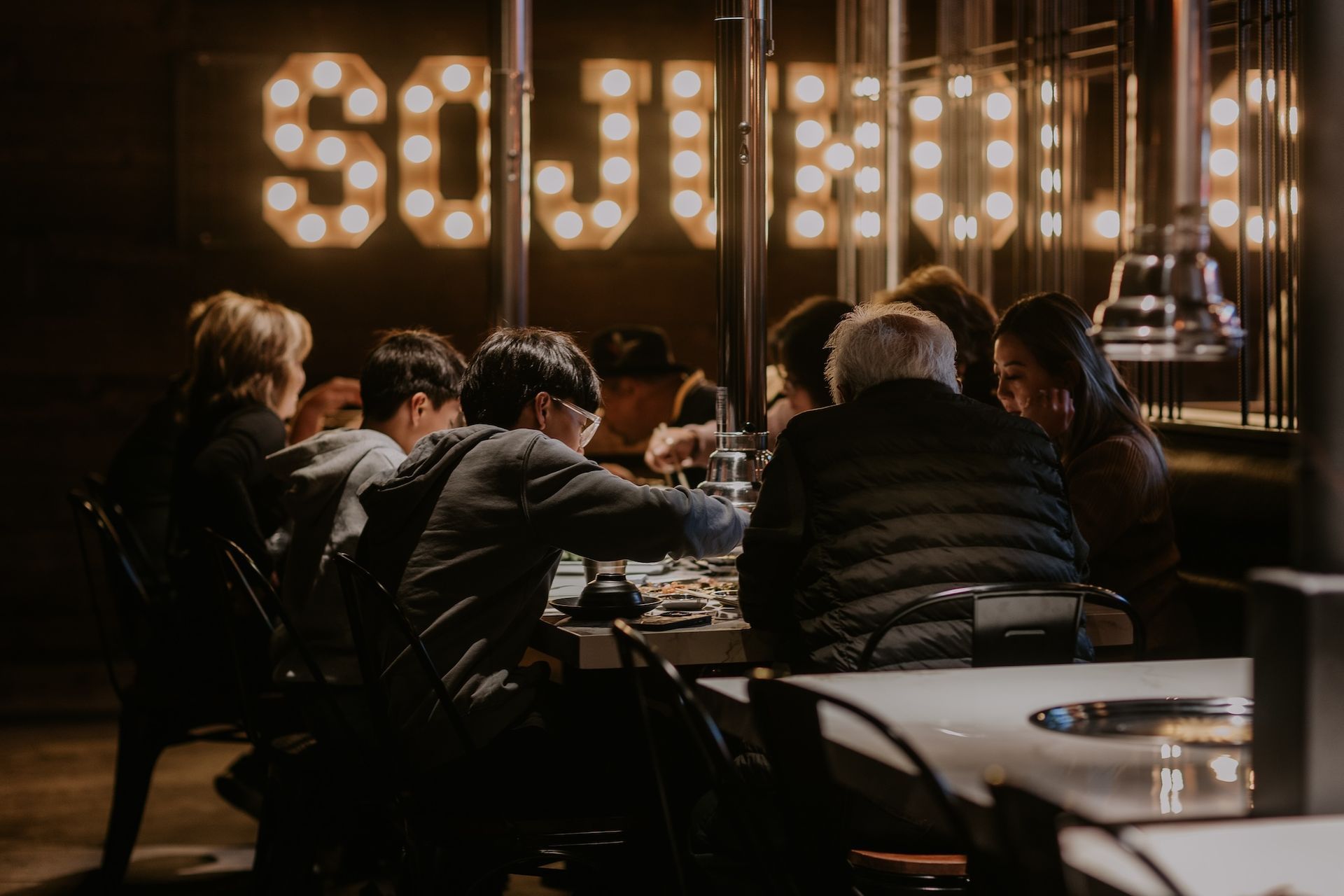a group of people are sitting at a table in a restaurant .
