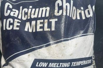 Bag of calcium chloride ice melt with blue and white label, low melting temperature text