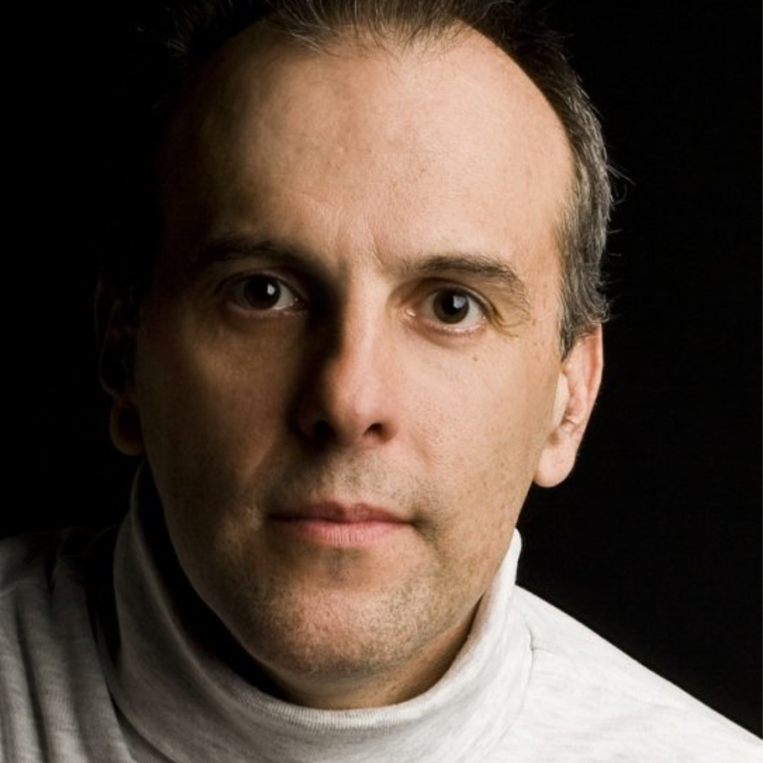 Close-up portrait of a person in a white shirt against a dark background
