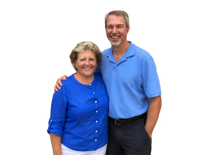 Smiling couple posing together against a white background, wearing blue shirts.