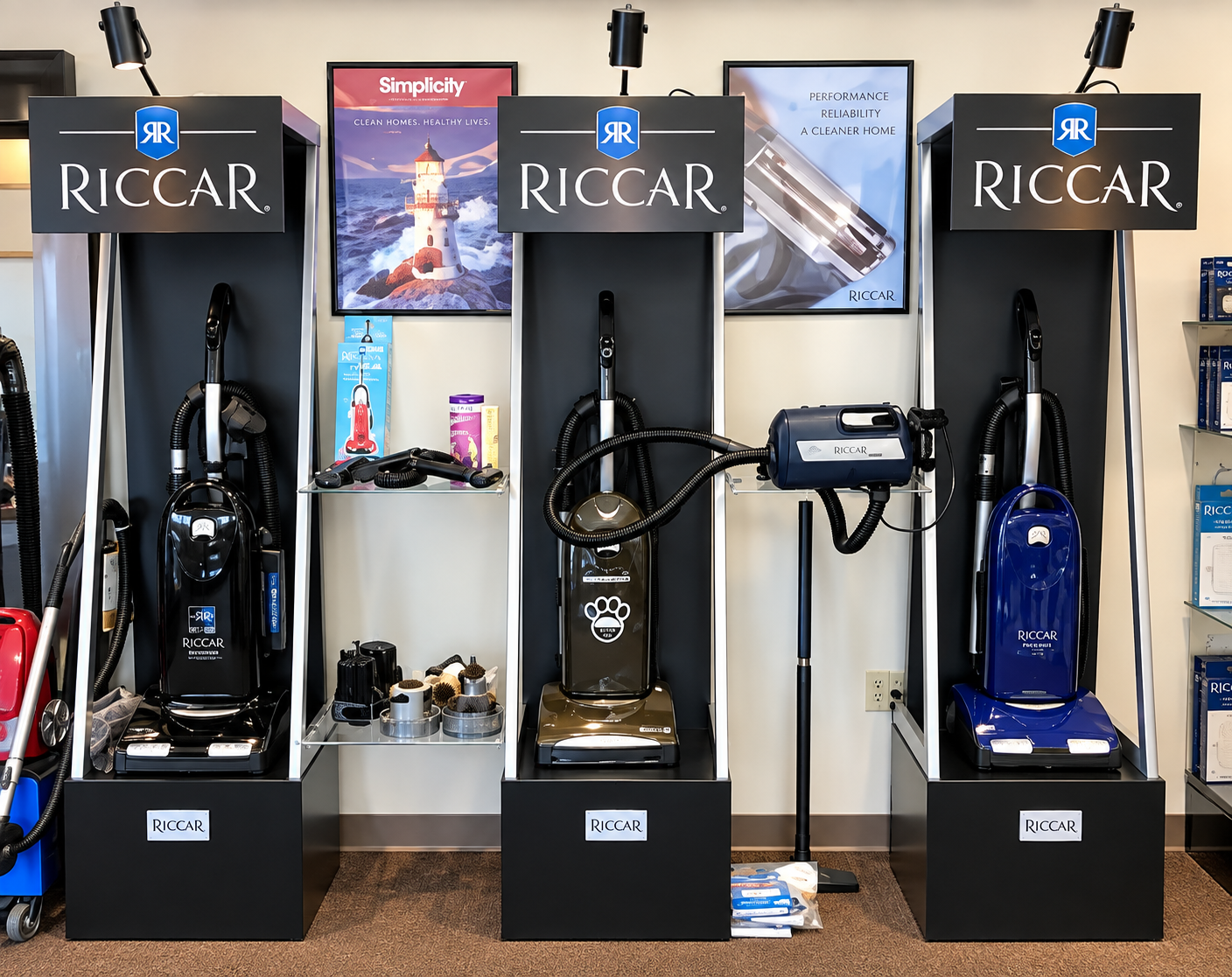 Three Riccar vacuum displays in a showroom, with black, red, and blue models.