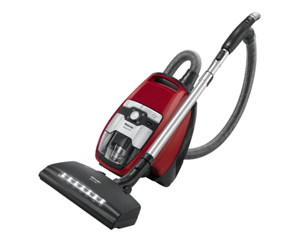 Red canister vacuum cleaner with black hose and floor nozzle on white background