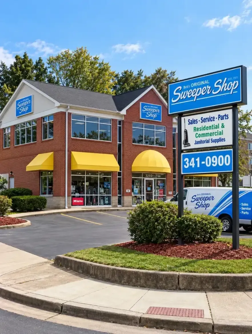 Sunshine Shop storefront with blue sign, yellow awnings, and parking lot on a sunny day