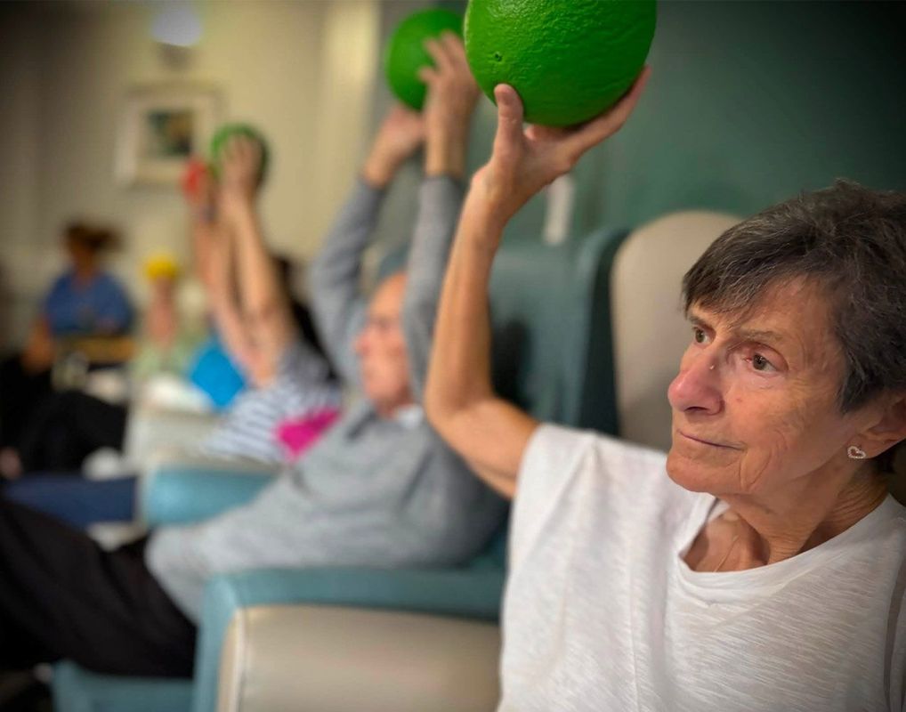 Care home exercise class with seated and standing movement