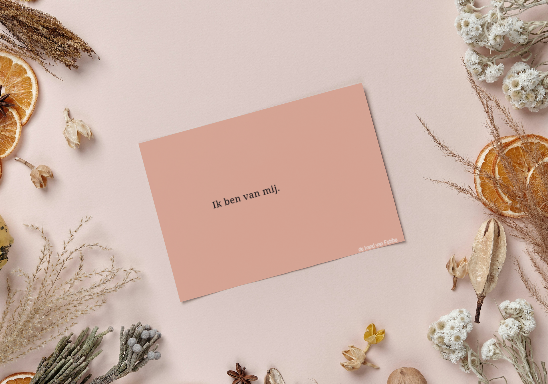 Boek en potlood in een oranje notitieboekje naast een vaas met bloemen op een houten tafel.