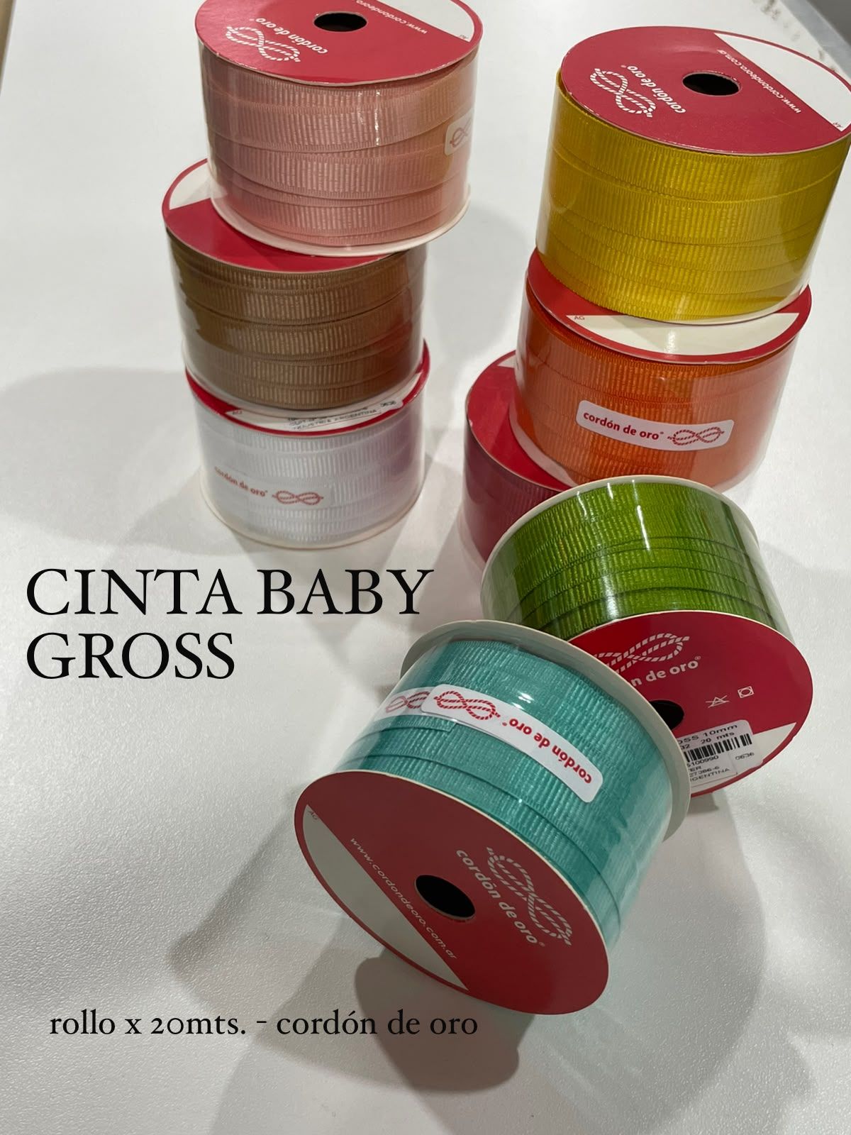 Rollos de cinta grosgrain de colores surtidos con el texto “CINTA BABY GROSS” sobre un fondo blanco.