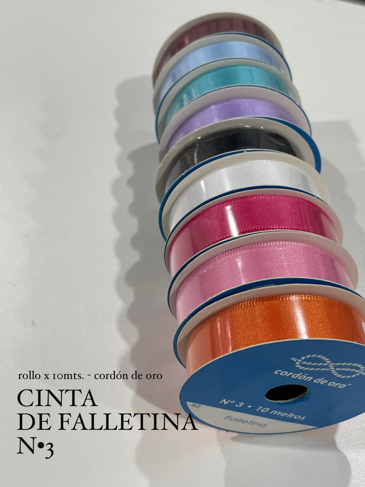 Pila de cintas de colores y carretes de cintas, con el texto en español “Cinta de paselitina Nº3”.