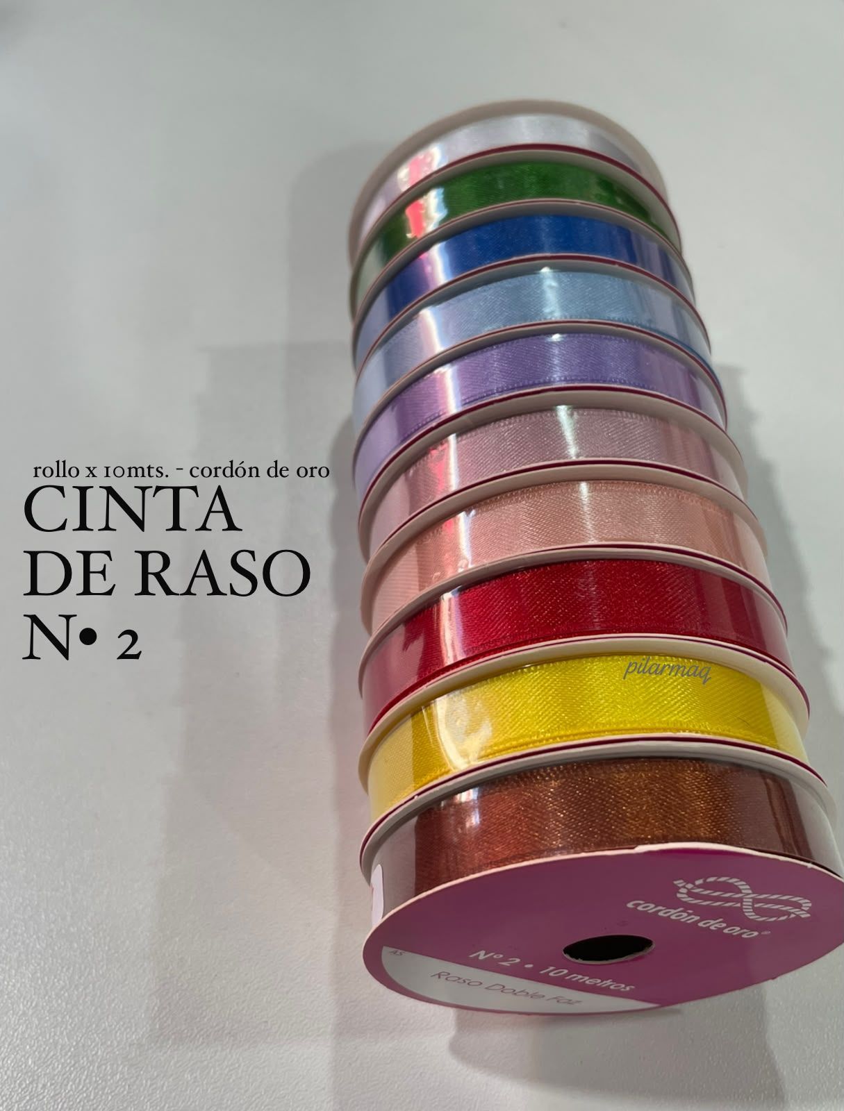 Pila de carretes de cinta de satén de colores con el texto “CINTA DE RASO N° 2” a la izquierda.