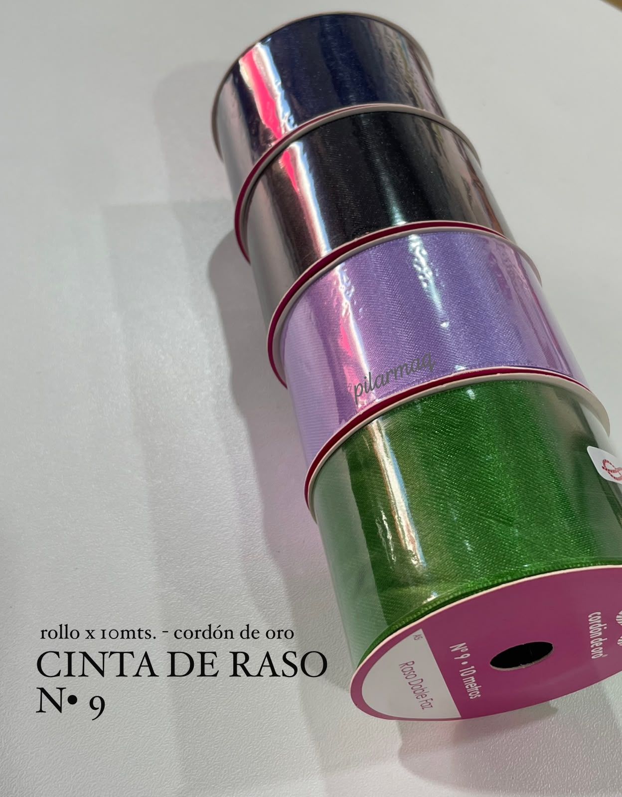 Tres rollos de cinta de color negro, lavanda y verde, apilados en diagonal sobre una superficie gris.