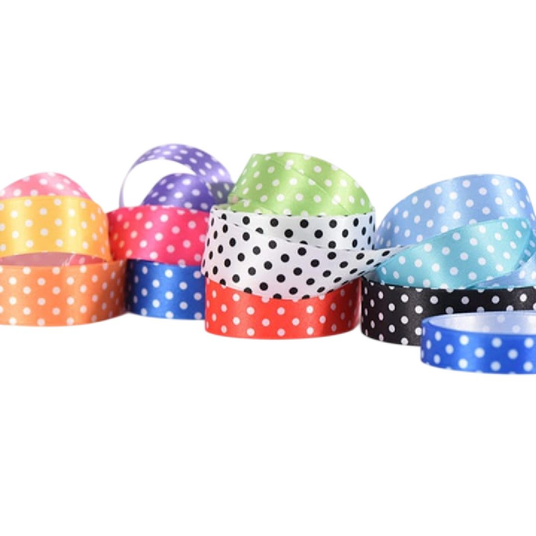 Cintas de lunares de colores apiladas en rollos superpuestos sobre un fondo blanco.