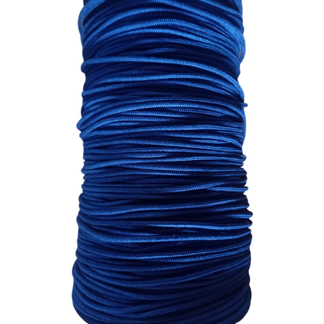 Carrete de cordón o hilo azul brillante enrollado firmemente en capas.