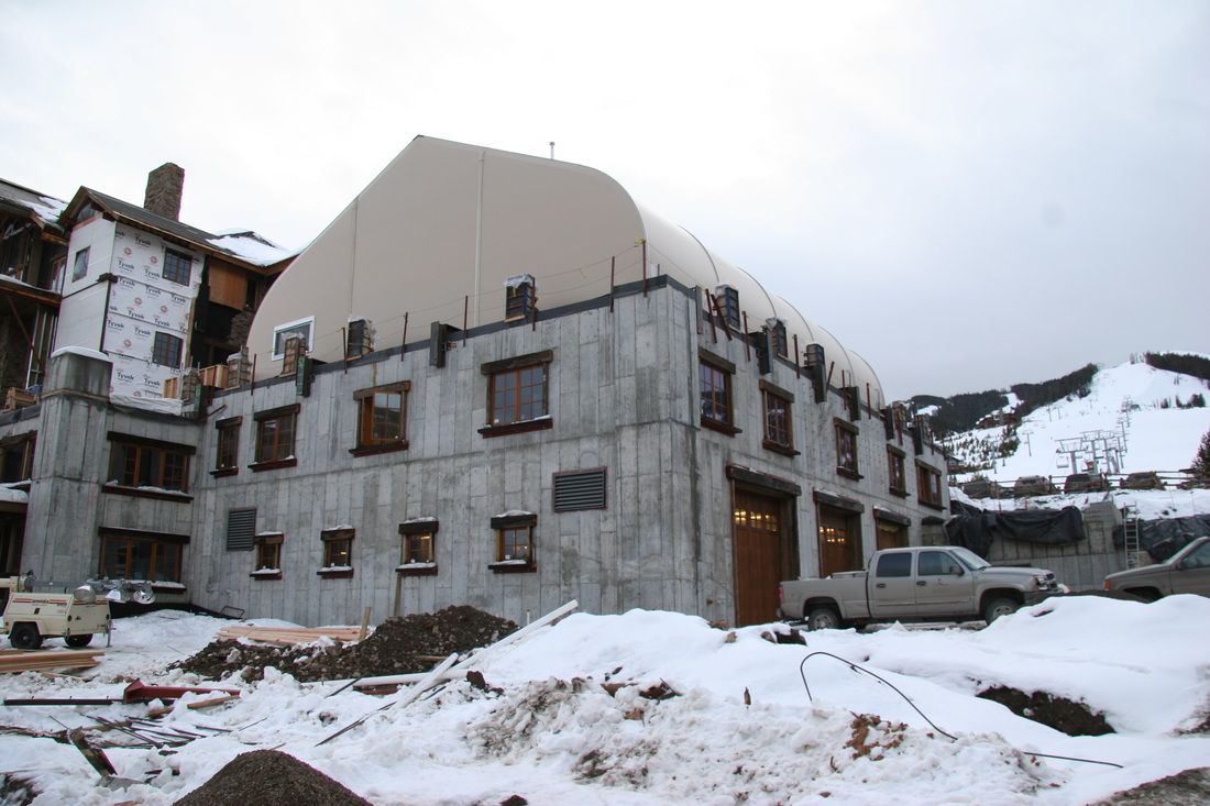 A large building under construction with a truck parked in front of it