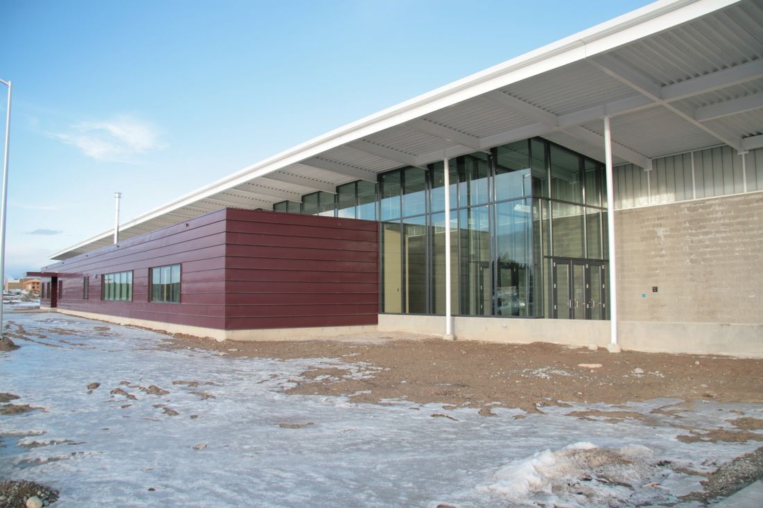 A large building with a lot of windows is covered in snow