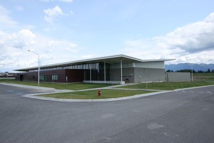 A large building is sitting on the corner of a street.