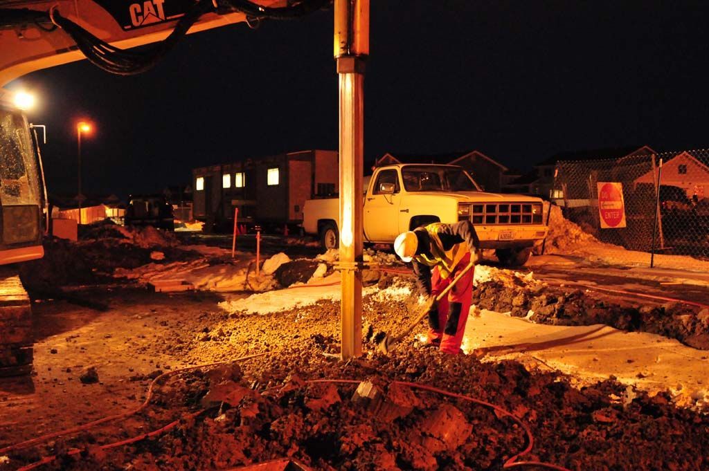 A man is working on a construction site at night.