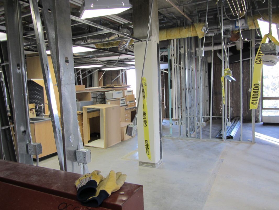 A pair of gloves are sitting on a table in a room under construction.