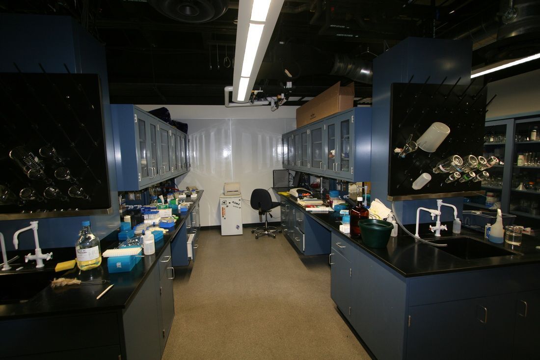 A laboratory with blue cabinets and black counter tops