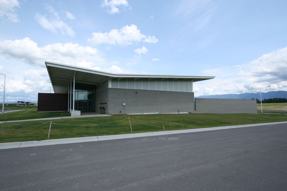 A large building with a curved roof is sitting on the side of a road.
