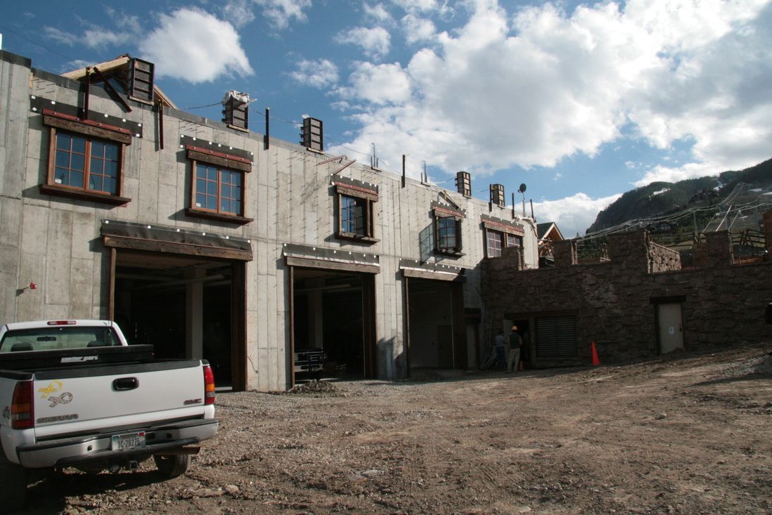 A white truck is parked in front of a building under construction