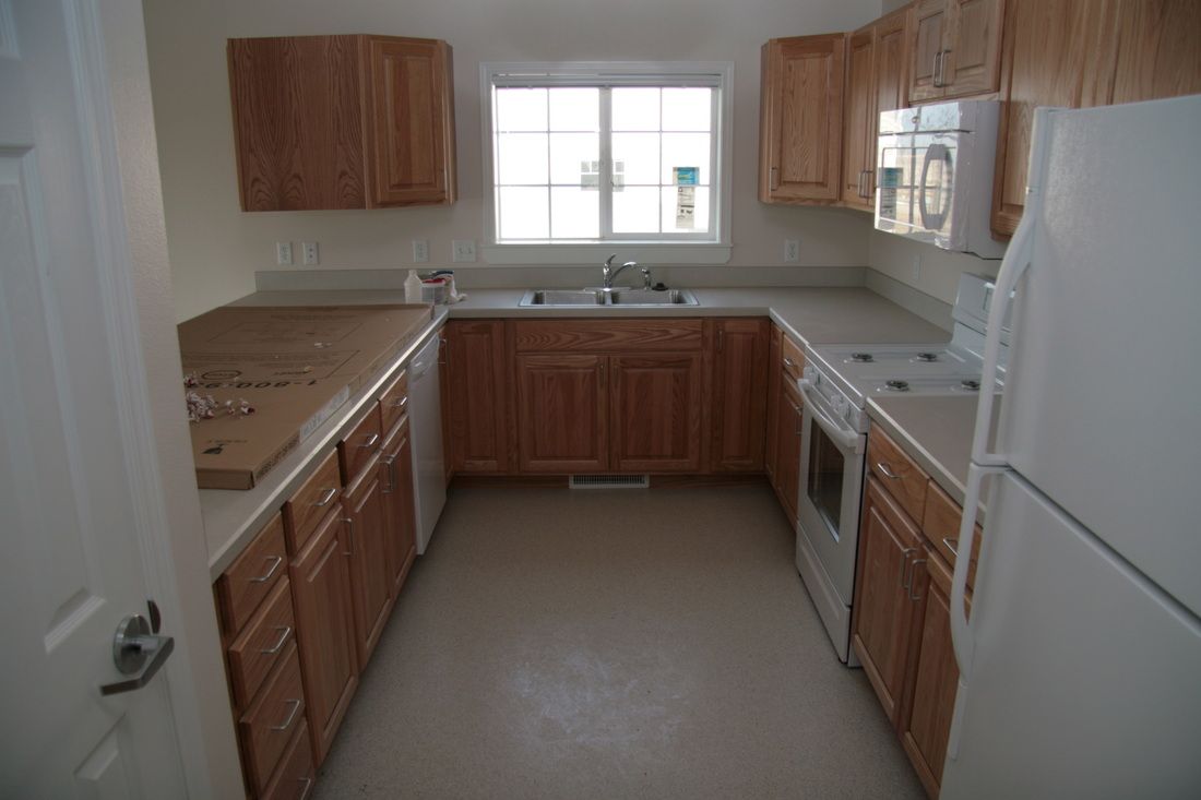 A kitchen with wooden cabinets and a white refrigerator