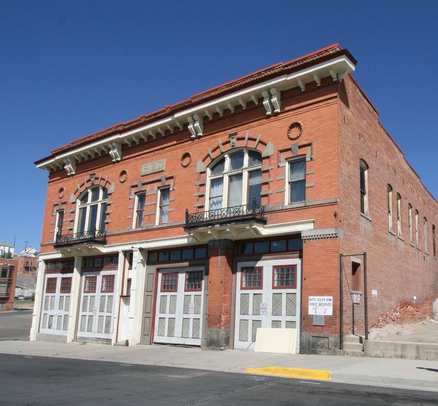 A large brick building with arched windows and a balcony