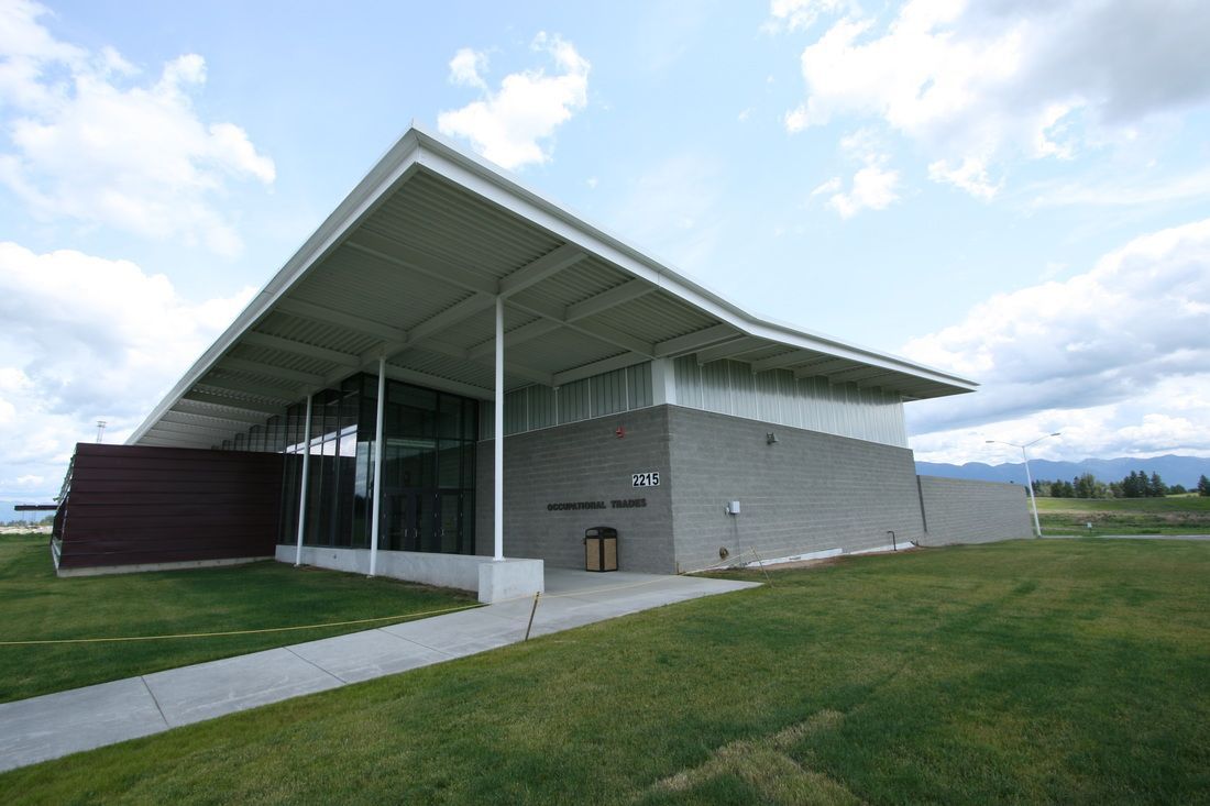 A large building with a white roof and a walkway leading to it