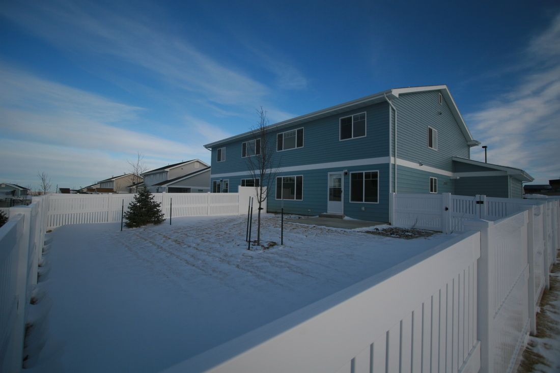 A blue house with a white fence in front of it