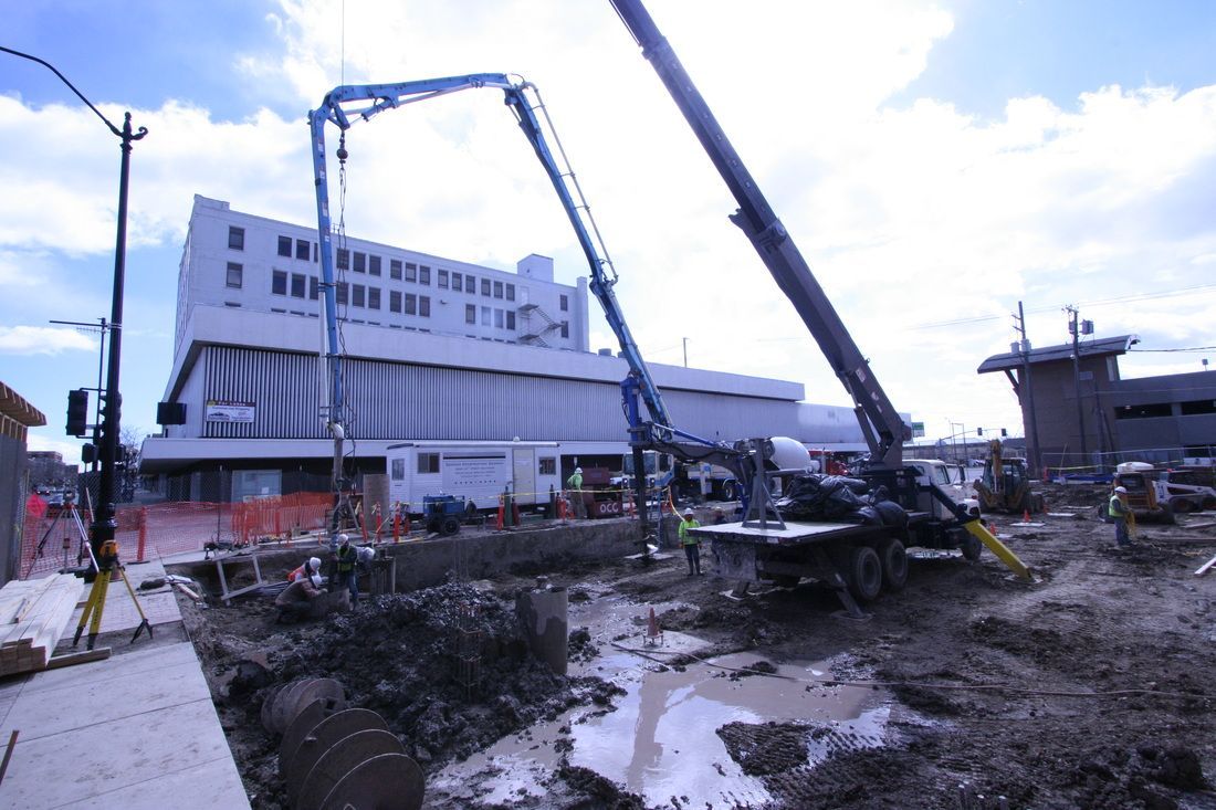 A construction site with a large building in the background