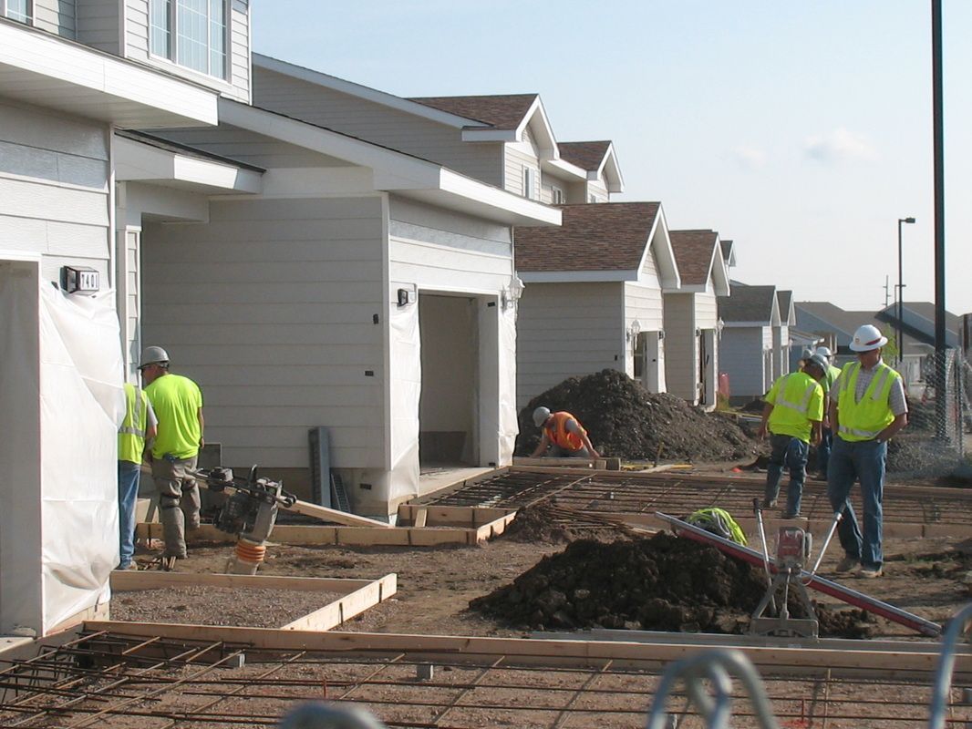 A group of construction workers standing in front of a row of houses