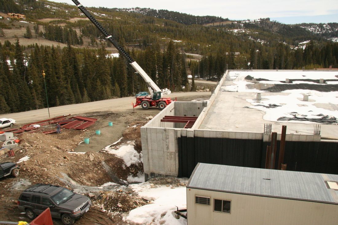 An aerial view of a construction site with a crane in the background