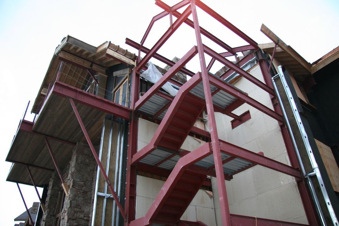 A building under construction with a red fire escape