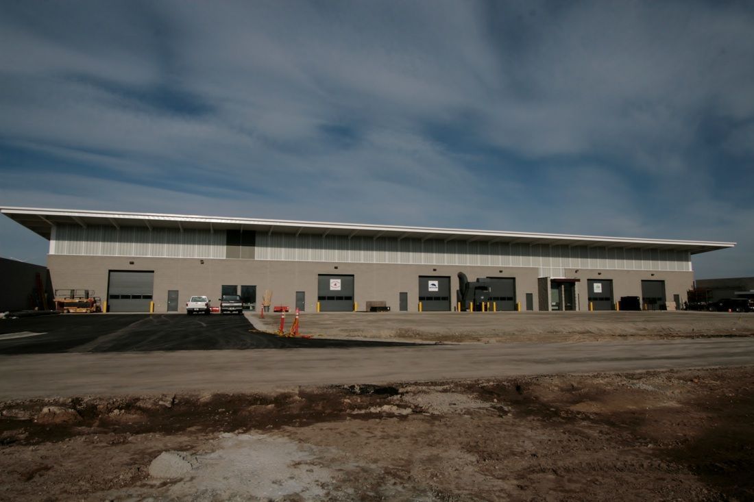 A large building is sitting in the middle of a dirt field.