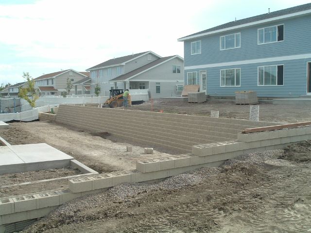 A brick wall is being built in front of a house