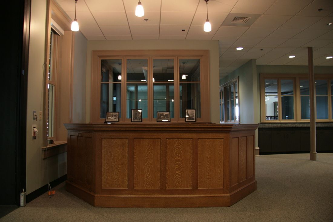 A wooden counter in a room with a lot of windows