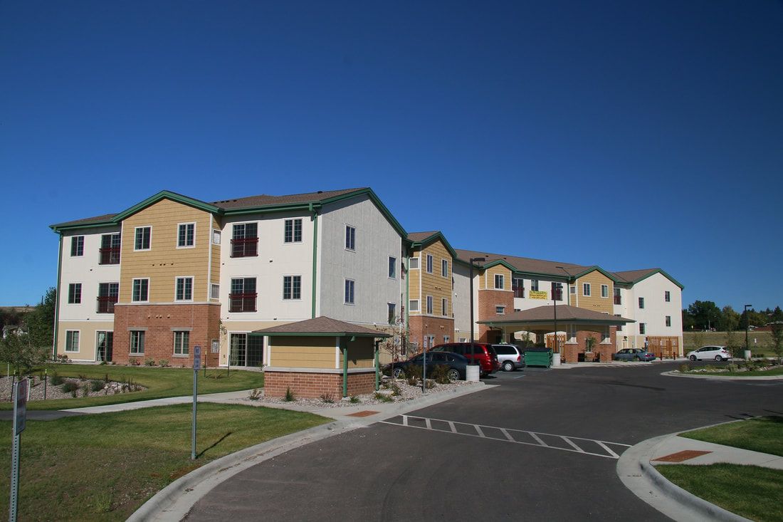 A large apartment building with cars parked in front of it