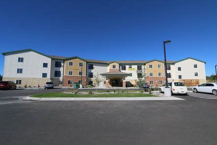 A large apartment building with cars parked in front of it.