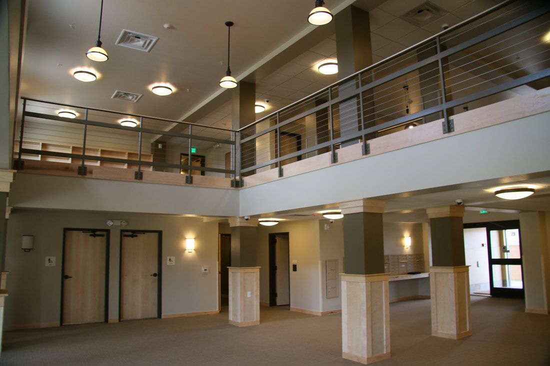 A large empty room with a balcony and columns