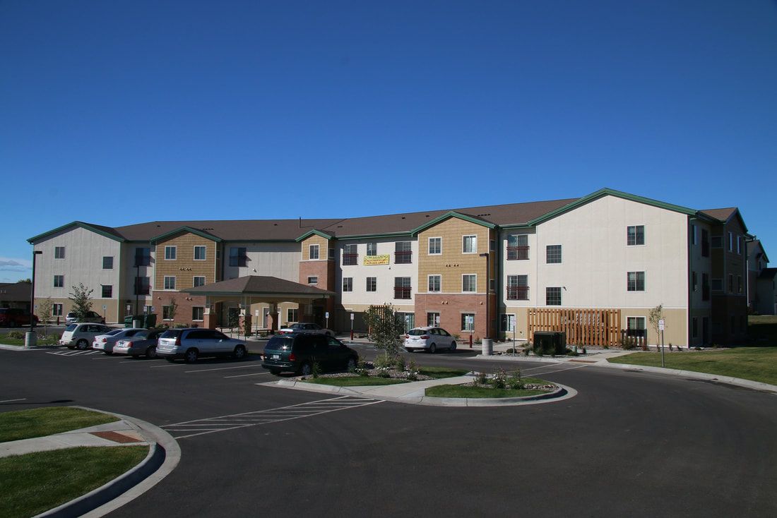 A large apartment building with cars parked in front of it