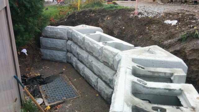 A large concrete wall is being built in a dirt area.