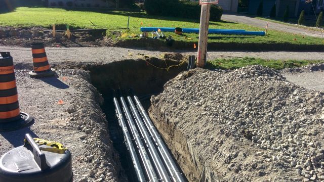 A bunch of pipes are being installed in a hole in the ground.