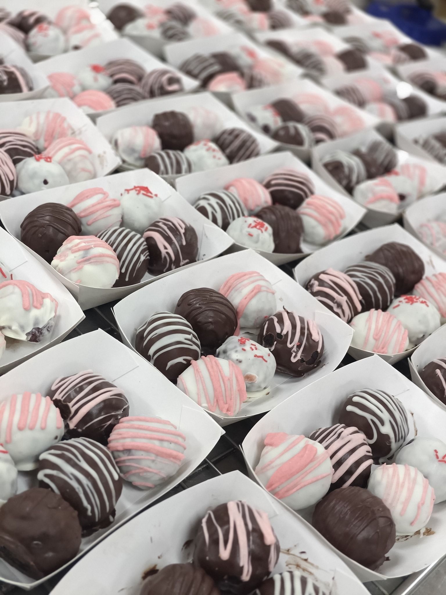 Rows of chocolate truffles in white paper trays — Atherton Bakehouse in Atherton, QLD